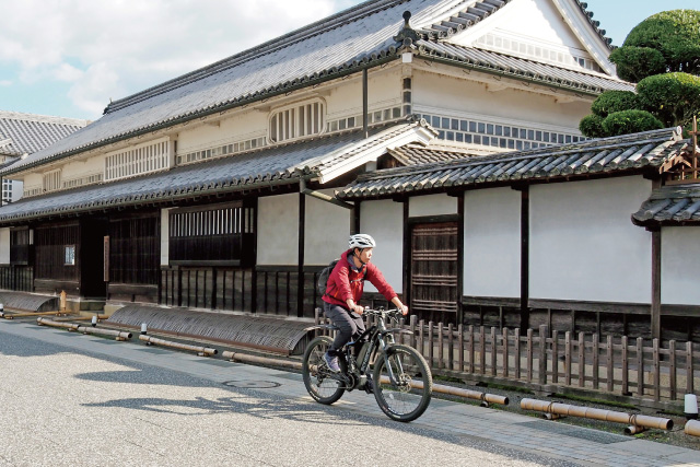 矢掛町の宿場町を1人の男性がE－バイクで走っている様子。